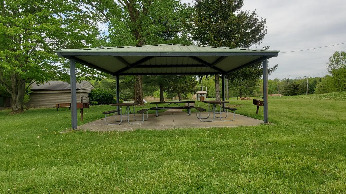 Shelter house in grassy area with trees with concrete pad, 3 picnic tables, and two grills.TBD