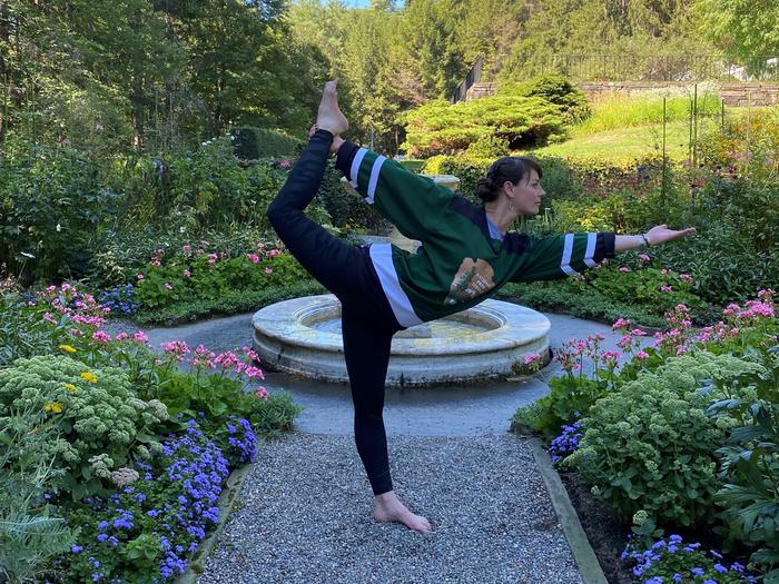 Person with NPS arrowhead shirt stands in a yoga pose in a formal gardenRanger (and yoga teacher) Jen Jackson practicing yoga in the formal garden.