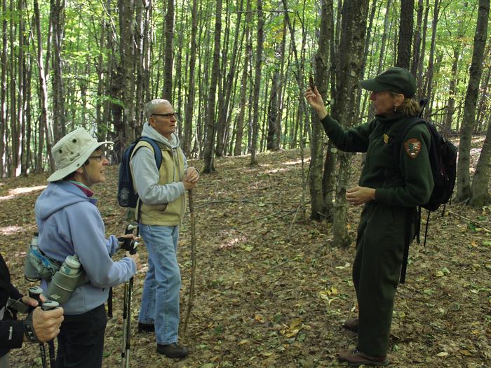 Park Ranger speaks to visitors on hiking trailRanger Marie leads visitors on a guided hike