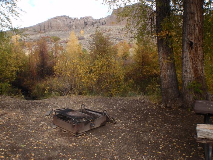 Fire pit, fall foliage and mesa in the background.In ground fire pit in the tent and picnic area.