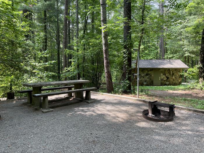Lake Powhatan #24 Campsite - picnic table, fire pit and bathhouse in background 