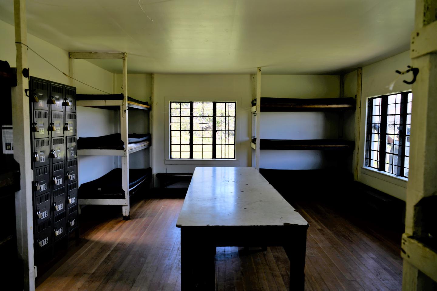 interior view of cabin showing stacked bunks, table, and lockers.Each cabin is equipped with 12 padded bunks, one long dining table, and a system of lockers for assignment of wood. Not pictured in the kitchen: wood stove, propane stove, and sink.