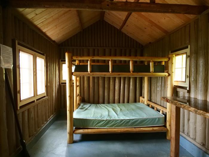 Wooden bunkbeds inside of a cabin.