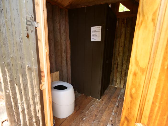 Composting toilet within primitive bathroom.