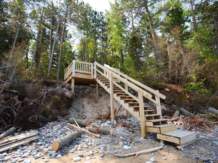 Large wooden staircase leading from deck to beach.