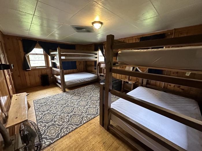 Historic forest service cabin bedroom with bunk beds.Star Meadow Guard Station bedroom interior with two bunk beds with queen and full mattresses, sleeps 6.