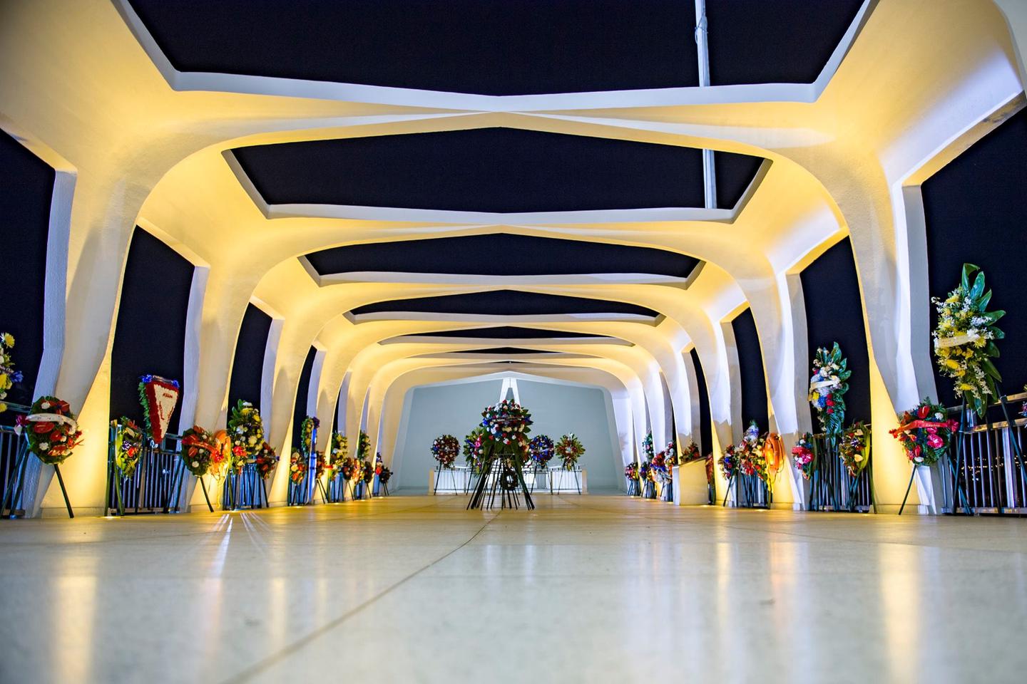 White memorial with wreaths at nightWreaths decorate the inside of the USS Arizona Memorial, before dawn on December 7