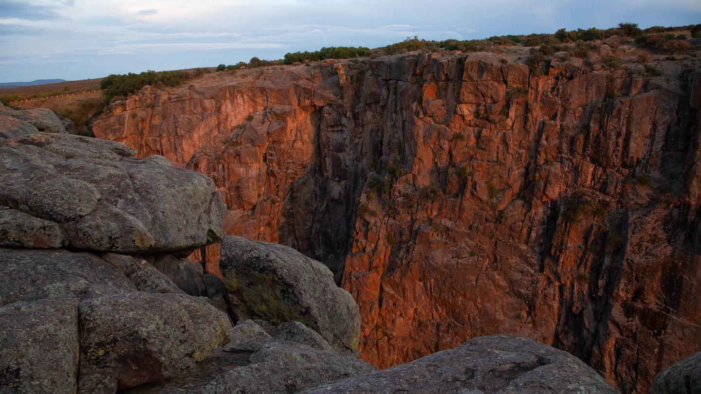 Sunlit Black Canyon of the Gunnison cliff face as seen from the South Rim 