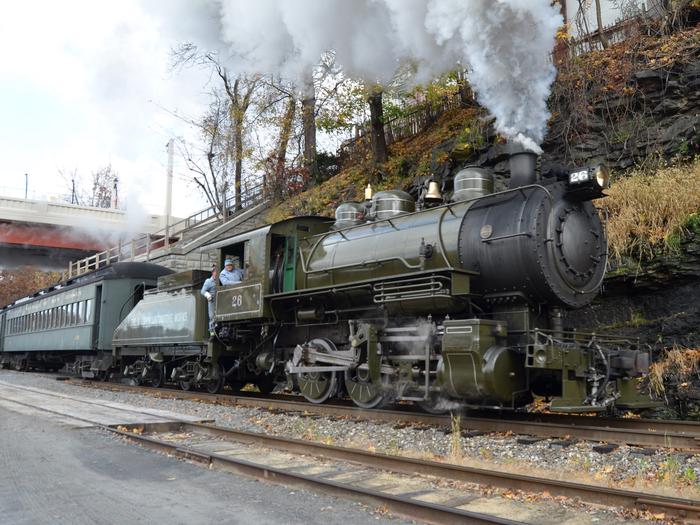 Dark green steam engine chugs along railroad tracksThe Baldwin Locomotive Works #26 steam engine travels along the Carbondale Line.