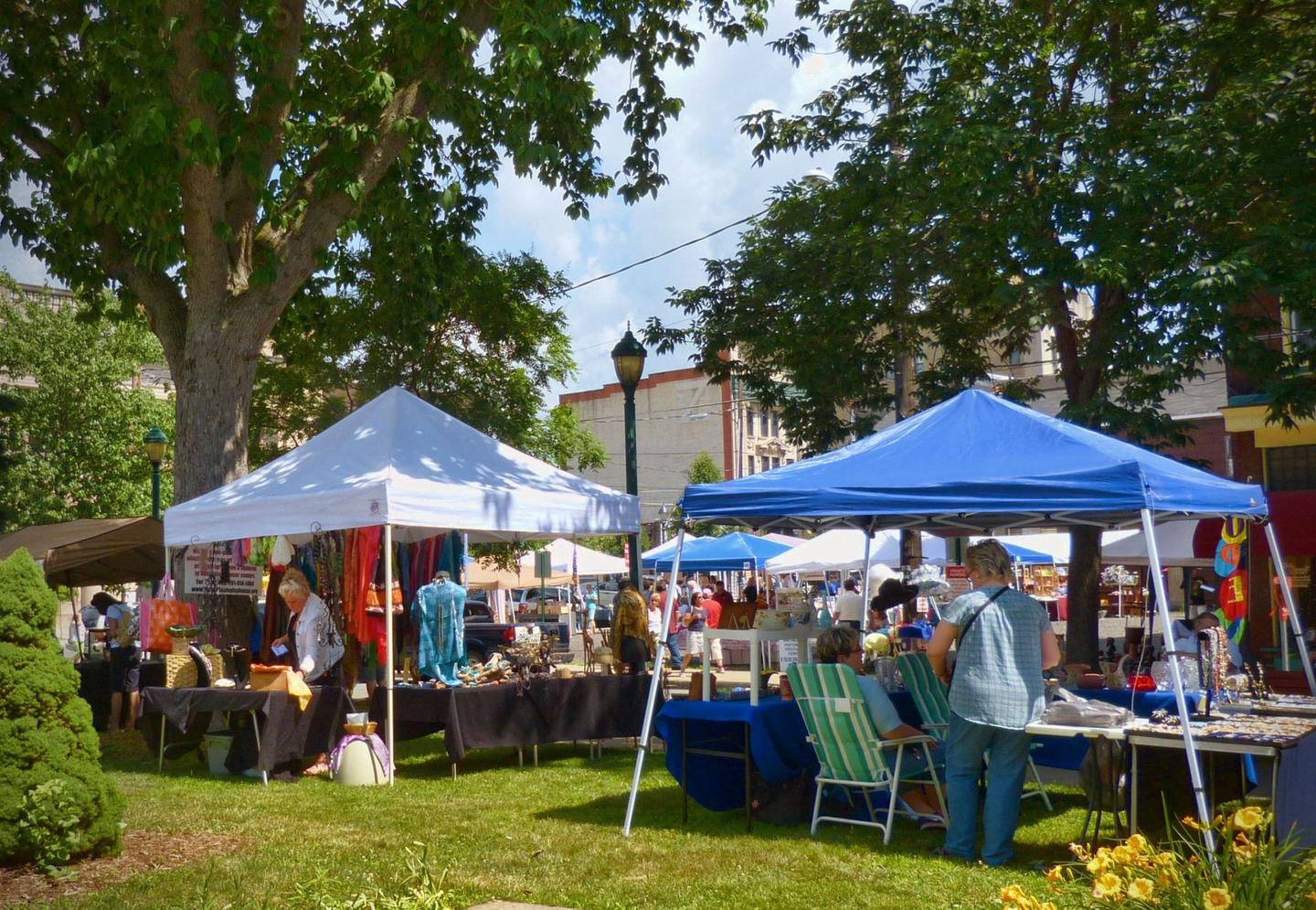 An outdoor space with a lawn and several pop up tents and street vendorsVendors will available throughout the Carbondale Pioneer Nights event selling food, refreshments, and more!