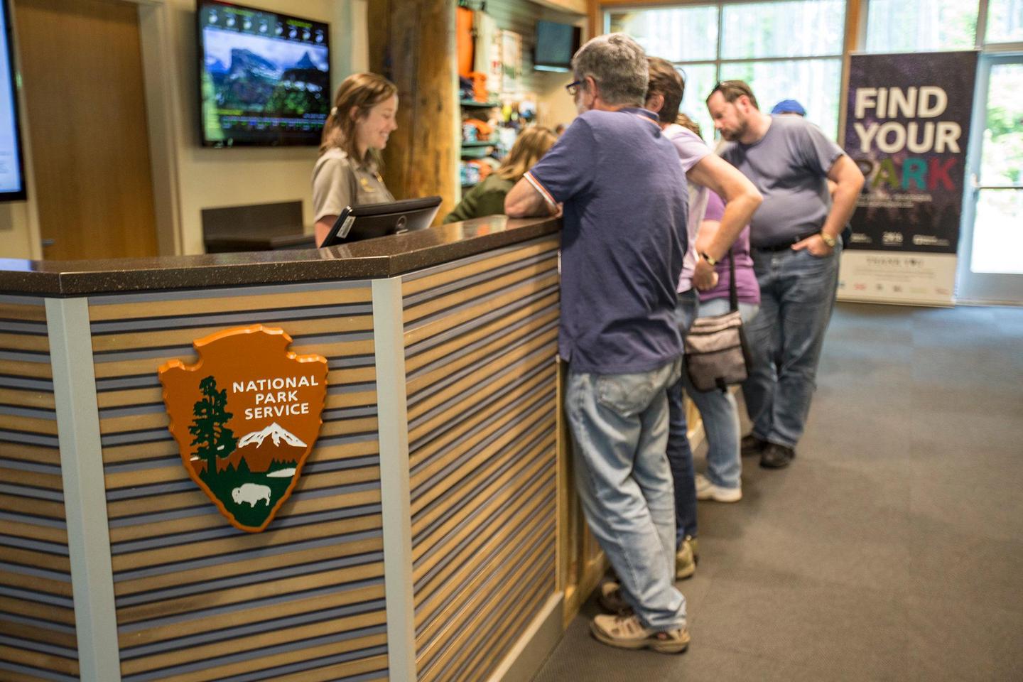 A ranger helps visitors in the Apgar Visitor Center.