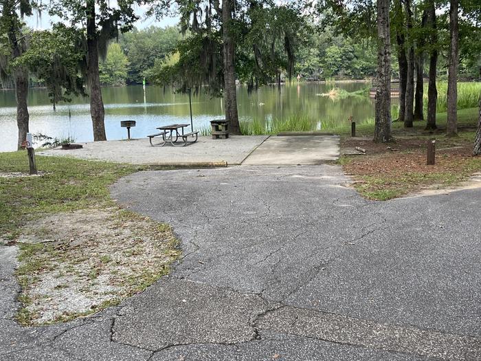 A photo of Site 67 of Loop PBLU at BLUFF CREEK with Picnic Table, Electricity Hookup, Sewer Hookup, Fire Pit, Shade, Tent Pad, Full Hookup, Waterfront, Lantern Pole, Water Hookup