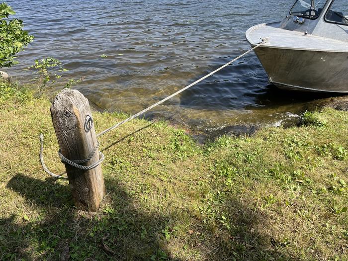 View of sand landing from shore with a boat tied to the mooring post on shore.Sand landing from shore