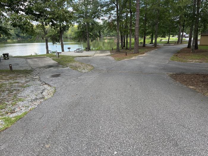 A photo of Site 67 of Loop PBLU at BLUFF CREEK with Picnic Table, Electricity Hookup, Sewer Hookup, Fire Pit, Shade, Tent Pad, Waterfront, Lantern Pole, Water Hookup