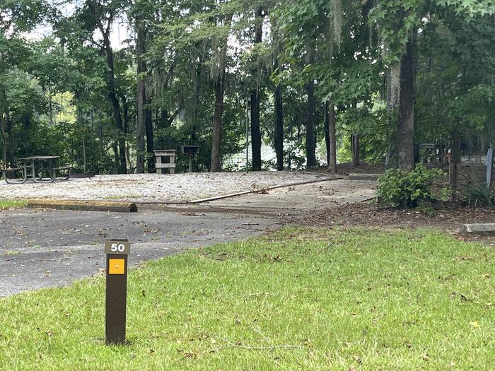 A photo of Site 50 of Loop RFOR at BLUFF CREEK with Picnic Table, Electricity Hookup, Sewer Hookup, Fire Pit, Shade, Tent Pad, Full Hookup, Waterfront, Lantern Pole, Water Hookup