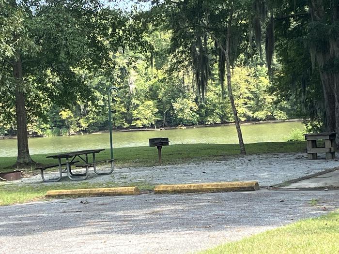 A photo of Site 61 of Loop PBLU at BLUFF CREEK with Picnic Table, Electricity Hookup, Sewer Hookup, Fire Pit, Shade, Tent Pad, Full Hookup, Waterfront, Lantern Pole, Water Hookup