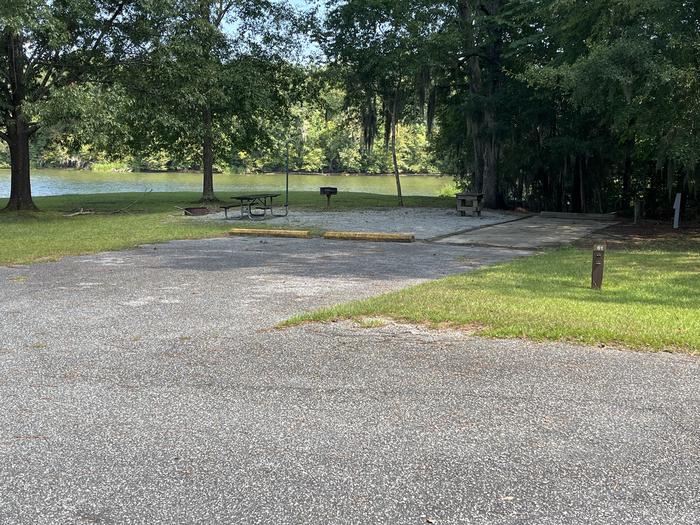 A photo of Site 61 of Loop PBLU at BLUFF CREEK with Picnic Table, Electricity Hookup, Sewer Hookup, Fire Pit, Shade, Tent Pad, Waterfront, Lantern Pole, Water Hookup