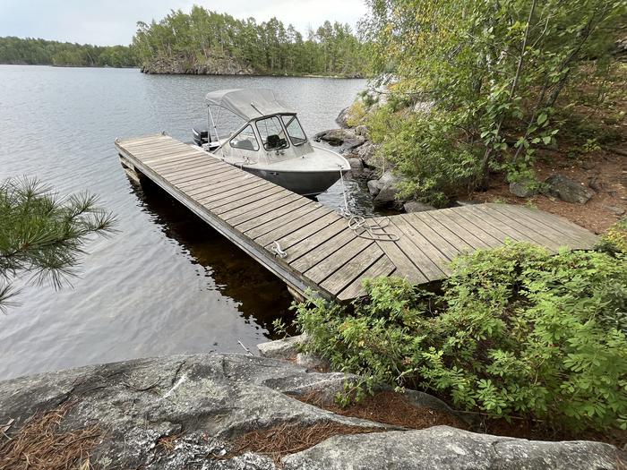 View of dock landing from shore with a boat tied to the dock.View of dock landing from shore