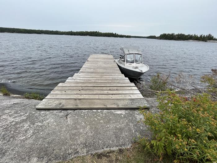View of dock landing from shore with a boat tied to the dock.Dock landing from shore