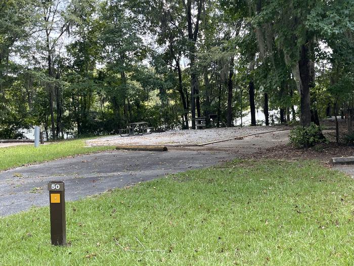 A photo of Site 050 of Loop OAKW at WHITE OAK (CREEK) CAMPGROUND with Picnic Table, Electricity Hookup, Sewer Hookup, Fire Pit, Shade, Food Storage, Tent Pad, Full Hookup, Waterfront, Lantern Pole, Water Hookup