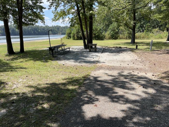 A photo of Site 105 of Loop RCHA at WHITE OAK (CREEK) CAMPGROUND with Picnic Table, Electricity Hookup, Fire Pit, Shade, Waterfront, Lantern Pole, Water Hookup