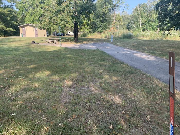 This site is located near a comfor station with a picnic table and fire rear to the left of the site. Hookups are located at the right rear side of the paved pad. 