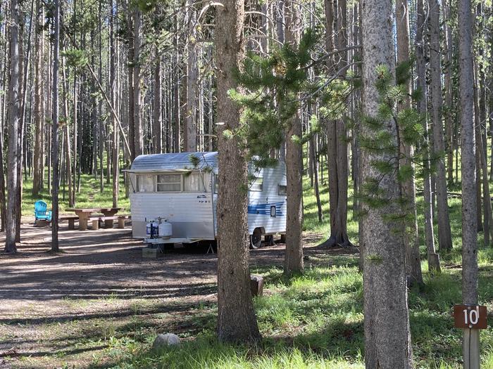 Camper in wooded campsiteCamper nestled in wooded campsite.