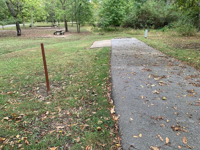 This site has a picnic table and fire pit on the left side of the paved pads. The hookups for this site are located to the right rear side of the paved parking pad. There is a walking/bike path near by and has an additional pad for camping supplies. 