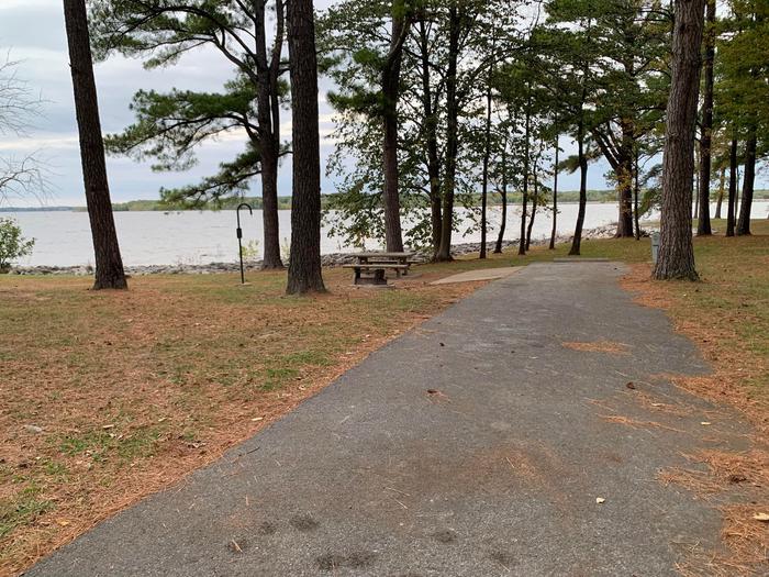 This site has a wonderful view of the lake with the picnic table and fire pit located on the left side of the paved parking/camping pad and the hookups are located to the right of the pad. 