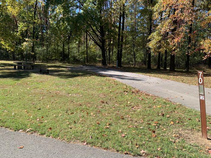 This is a full hookup site with all the hookups on the right side of the paved/parking pad. The picnic table and fire pit are located on the left side. There are many surrounding trees providing shade. This site also has an additional parking pad. 