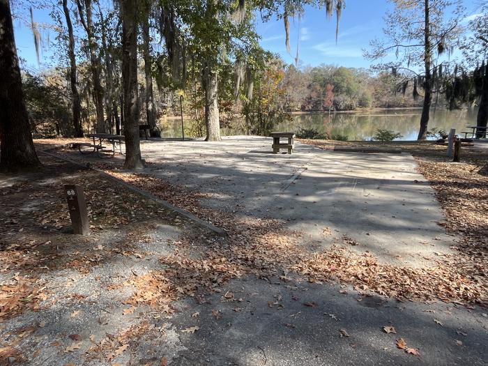 A photo of Site 68 of Loop PBLU at BLUFF CREEK with Picnic Table, Electricity Hookup, Fire Pit, Shade, Waterfront, Lantern Pole, Water Hookup