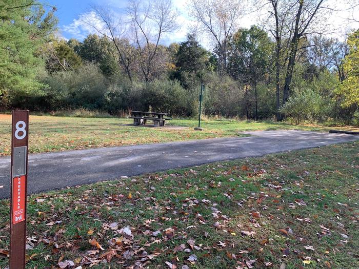 This site is furnished with a fire pit and picnic table on the left side of a paved pad. Hookups are on the right rear side of the pad. 