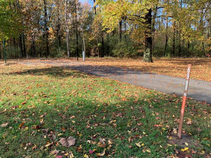 This site has a picnic table and fire pit located on the left side of the paved parking/camping pad. The hookups are on the right side of the pad. There are a lot trees on the site providing shade.