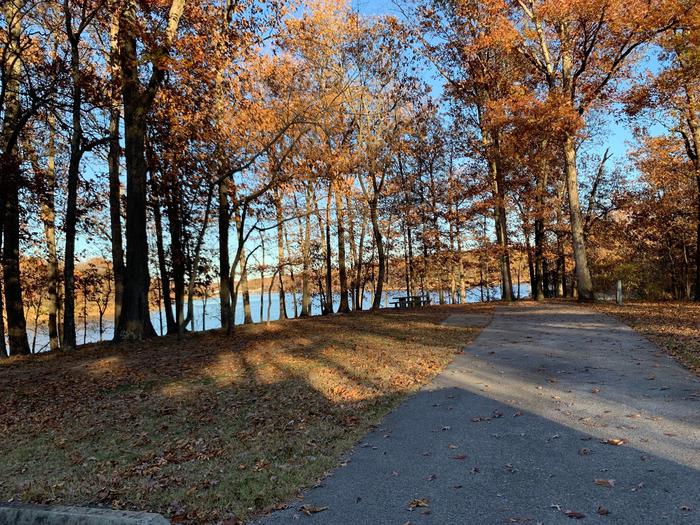 This site has a great view of the lake. The picnic table and fire pit are located on the left side of the paved parking/camping pad. The hookups are on the right side of the pad. 
