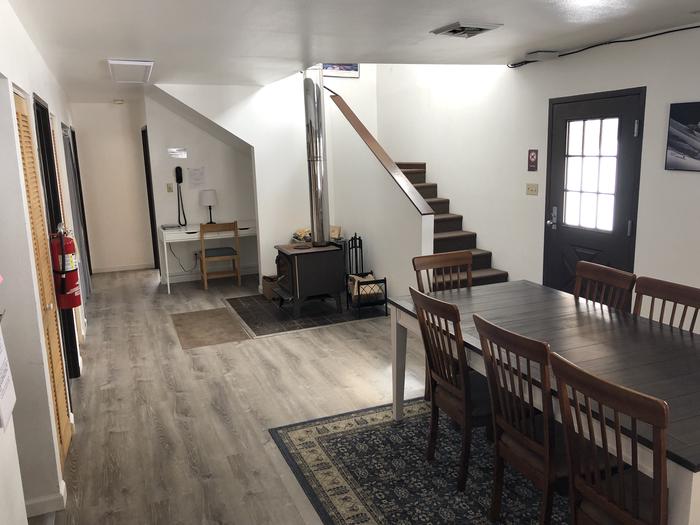 Ground floor of a building with a dining table and chairs and a wood stove in the cornerLiving Room #4