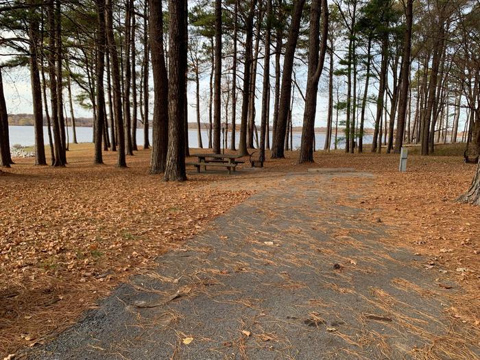 This site has a wonderful view of the lake with the picnic table and fire pit located on the left side of the paved parking/camping pad and the hookups are located to the right of the pad. 