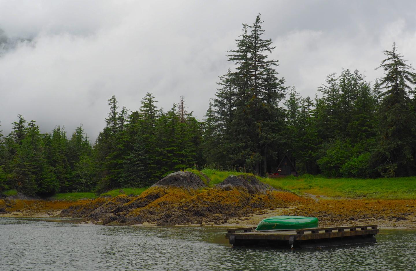Berg Bay with a canoe on a float with cabin in the background and treesBerg Bay and cabin