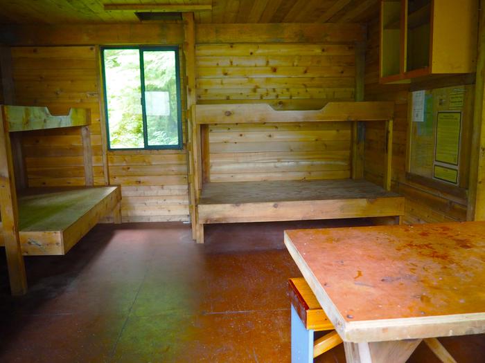 Frosty Bay Cabin, wooden interior of cabin with four bunks and a tableFrosty Bay Cabin interior