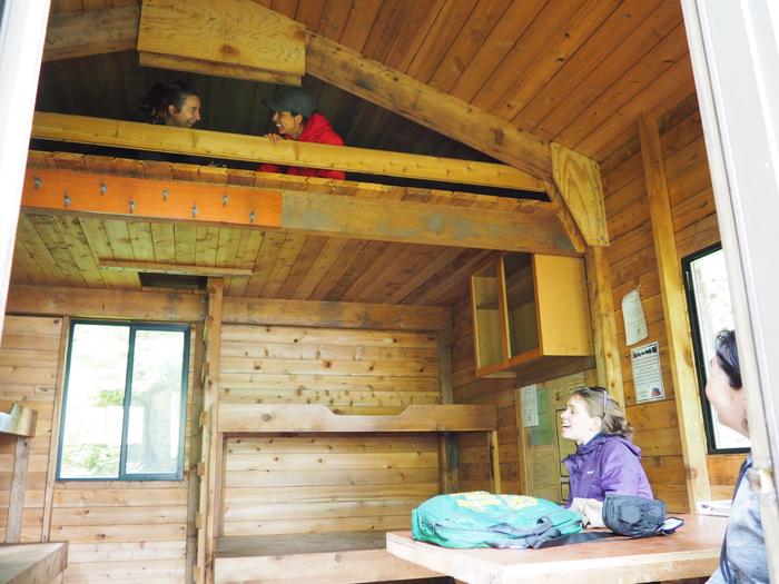 Two people in loft with two people at a table in a wood cabinEnjoying the loft in Frosty Bay cabin