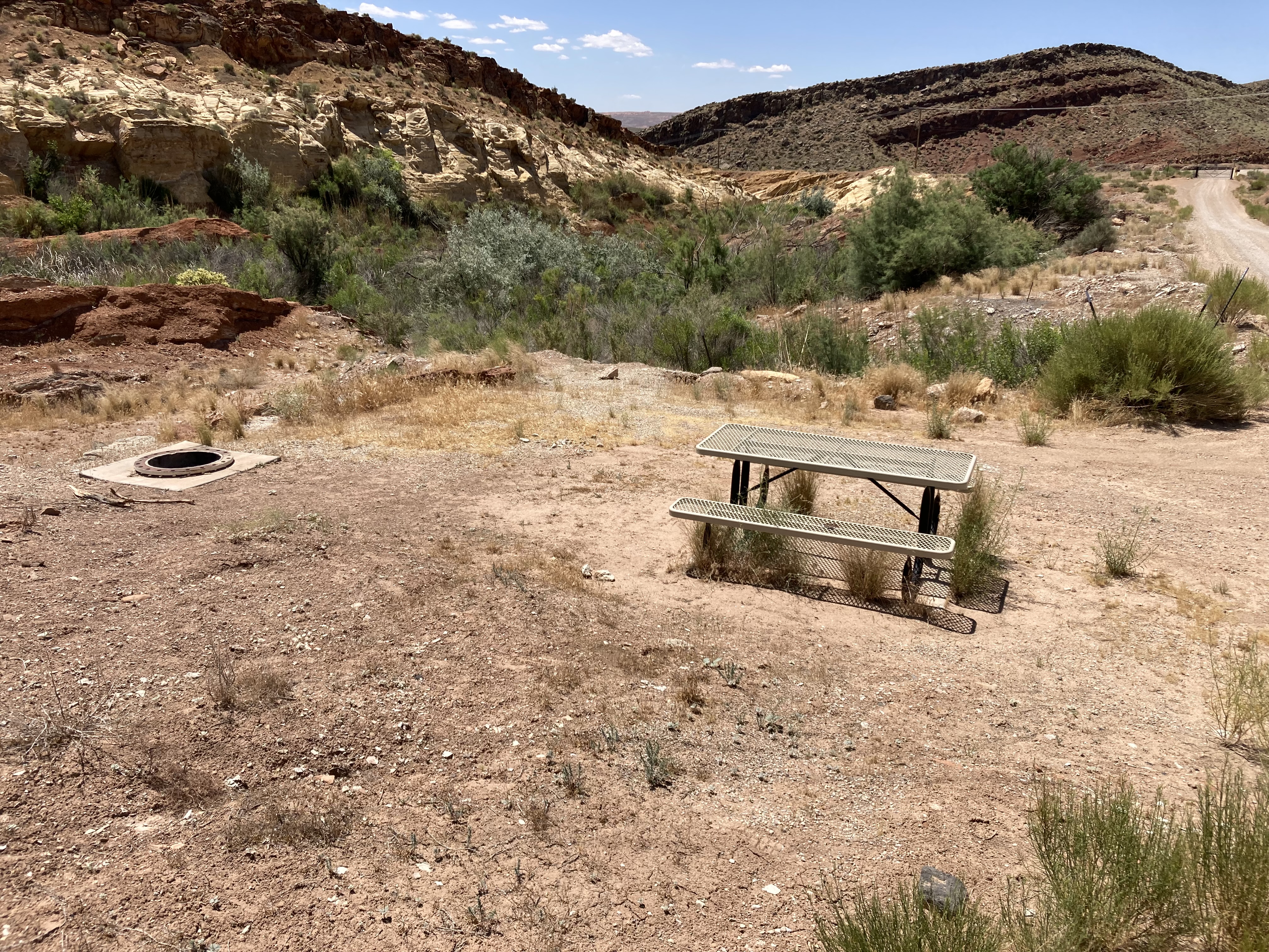 Flat, gravel campsite with a desert wash full at Quail Creek Reservoir Designated Dispersed Camping Area