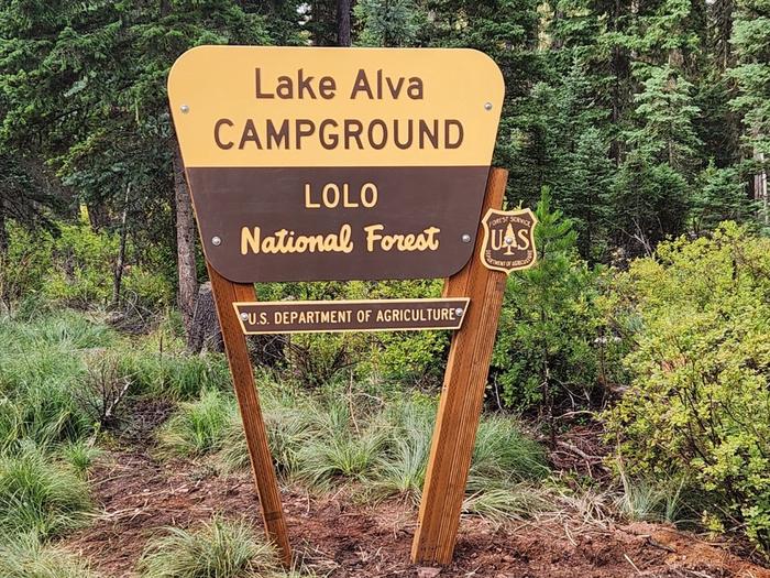A photo of the campground entrance sign. It reads: Lake Alva Campground, Lolo National Forest, U.S. Department of Agriculture.