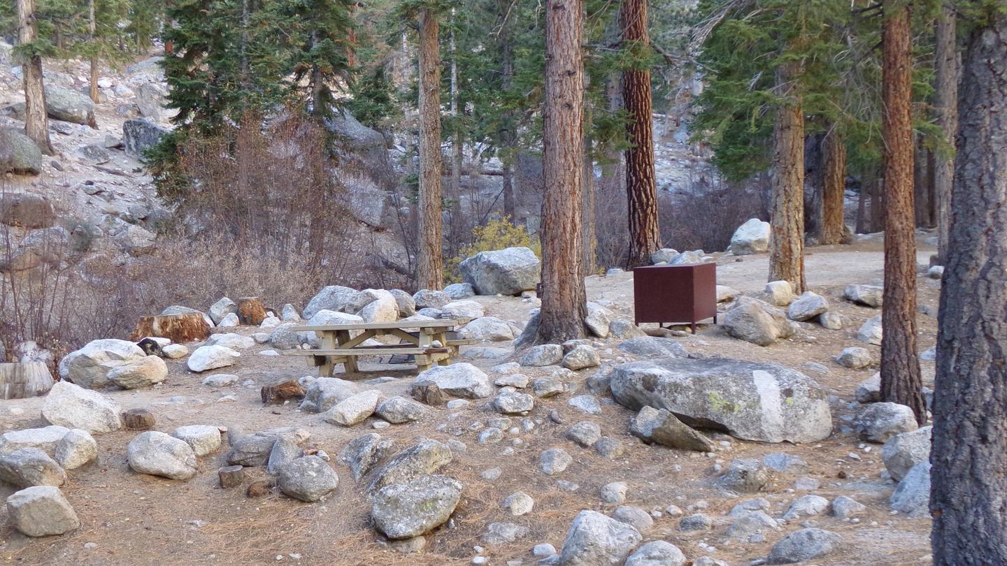 A Whitney Portal campsite with picnic table and bear box, nestled between boulders and near a creek.Whitney Portal Campsite