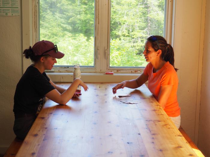 Two people playing cards on wooden tableEnjoying a card game at Deep Bay Cabin