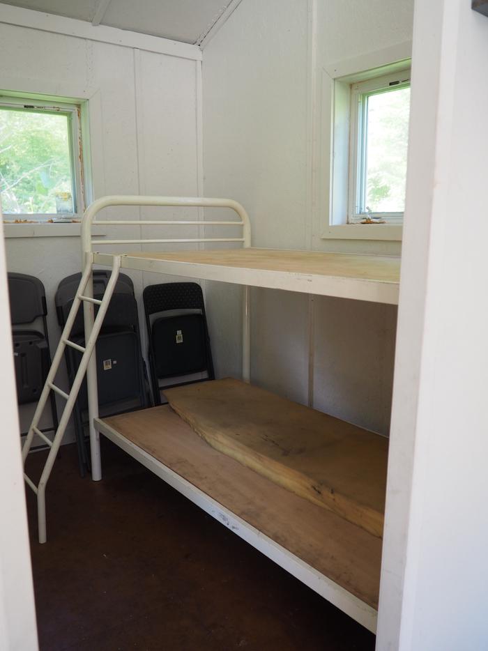 Deep Bay Cabin metal bunks with folding chairsDeep Bay cabin interior