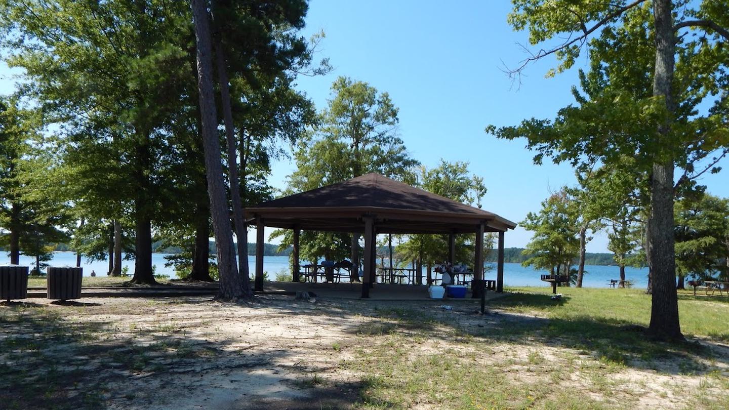 Palmer Point ShelterThis is a picture of the Palmer Point shelter. There are picnic tables under a covered shelter. There is a gravel walkway to the shelter. It has a grill located near the shelter and there are trash cans throughout the park. 