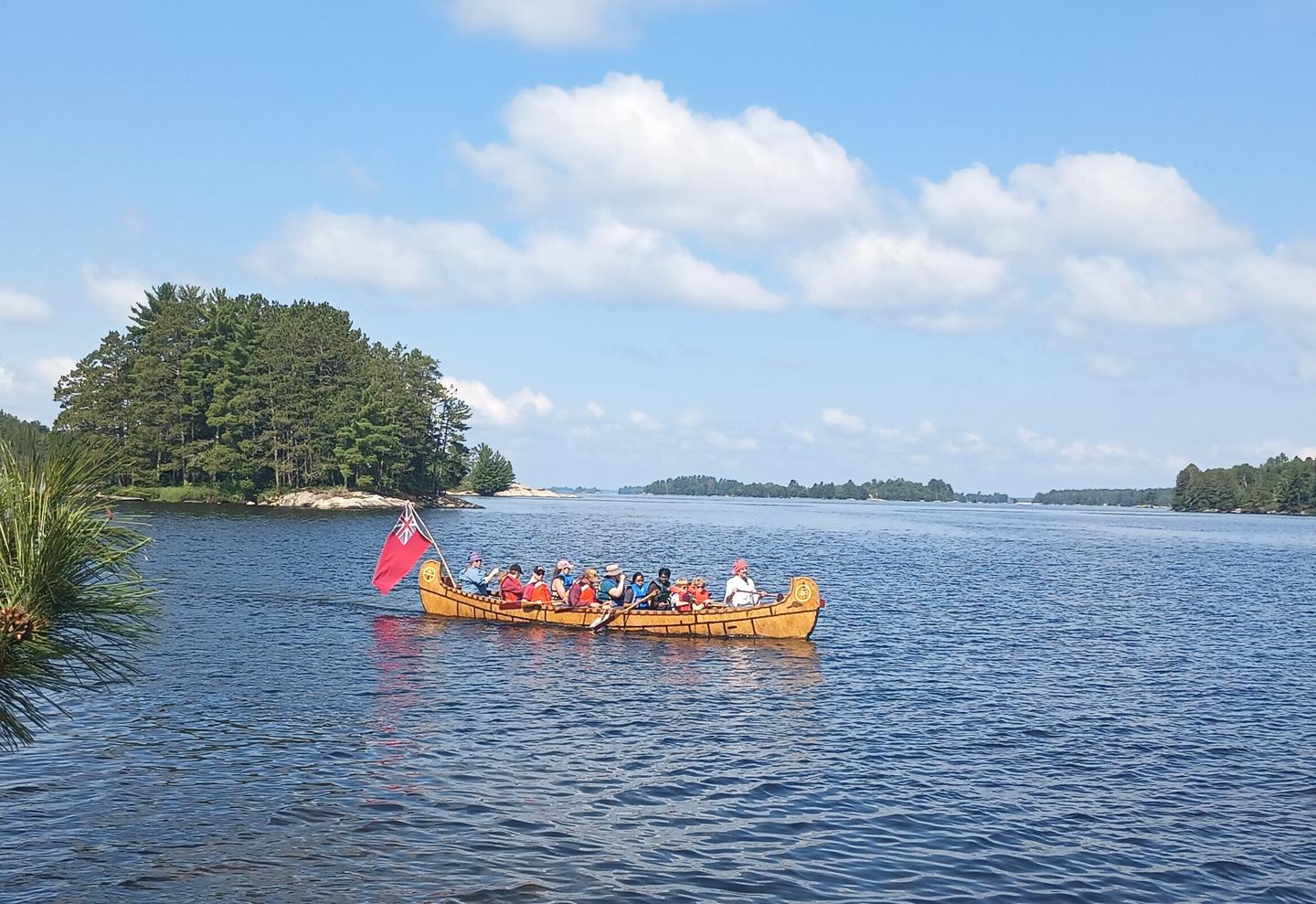 Park visitors paddle a 26-foot replica of a North Canoe