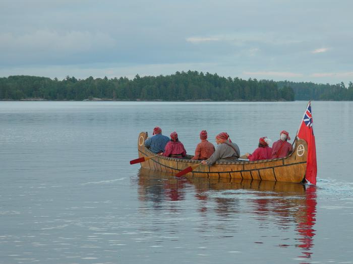 Visitors paddle a 26-foot replica of a birch bark north canoe.