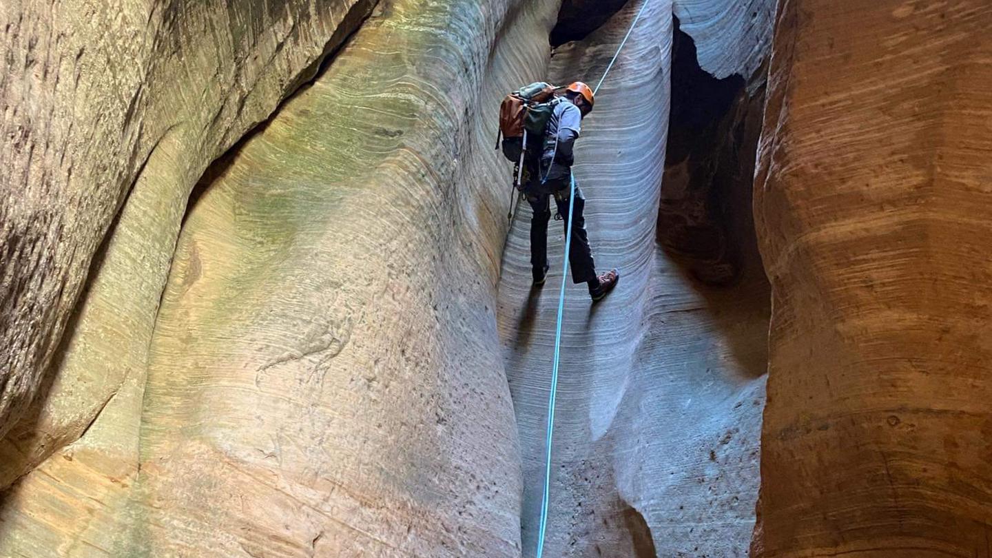 A hiker rappelling in Mystery Canyon.Mystery Canyon rappel