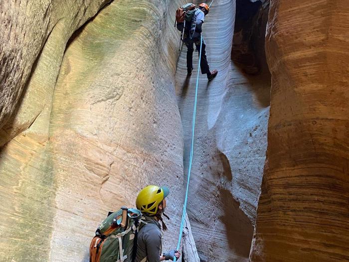 Hikers rappelling in Mystery Canyon