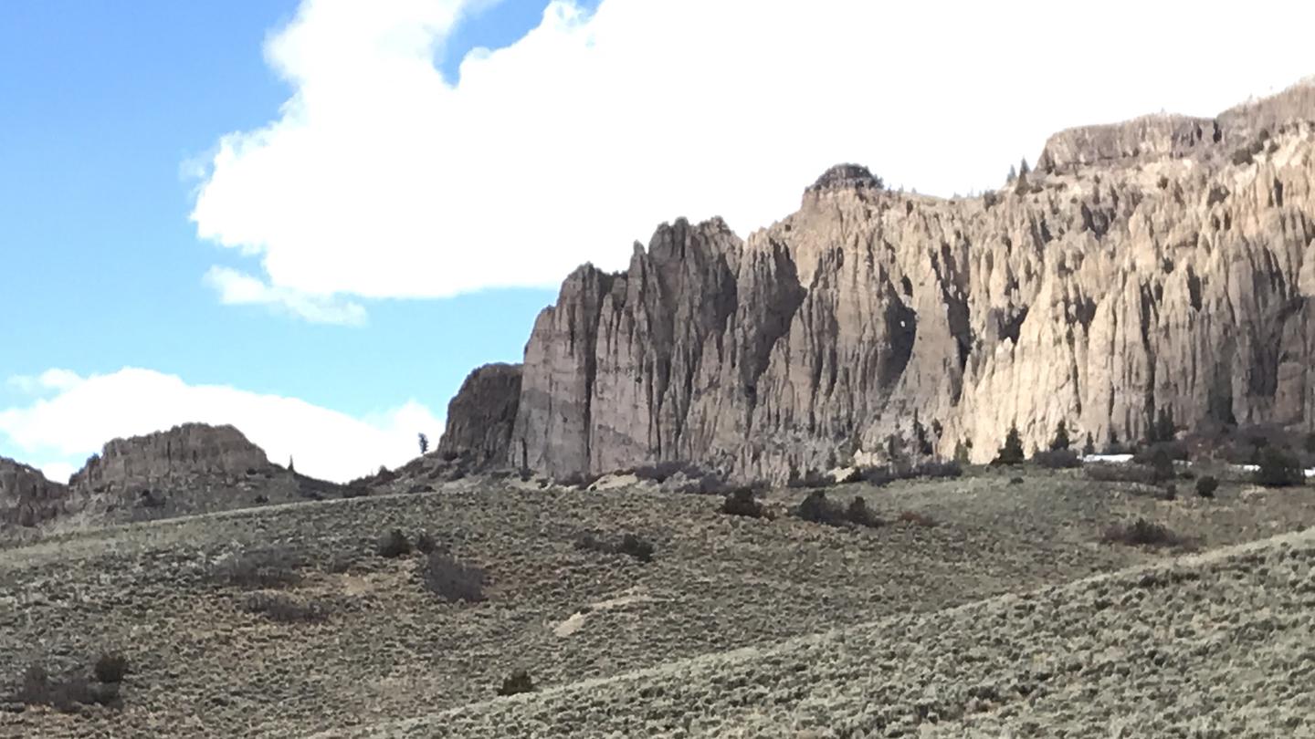 Dillon Pinnacles, a rock formation, basks half in the sunlight and half in the clouds. The Dillon Pinnacles Trail and Overlook are not far from Red Creek Campground